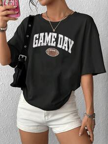 Camiseta informal de manga corta y cuello redondo para mujer con estampado gráfico de fútbol para el día del partido. Top cómodo y elegante para el día a día, ideal para amantes del deporte y salidas informales. - Negro - Ver 1