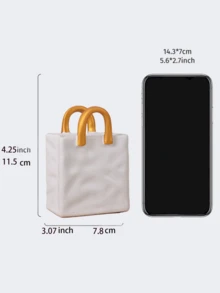 1件独特的白色和金色手提包造型树脂花瓶，这款时尚花瓶配有金属把手，非常适合在咖啡桌、梳妆台上或卧室装饰中展示鲜花，为您的家增添迷人的现代气息。