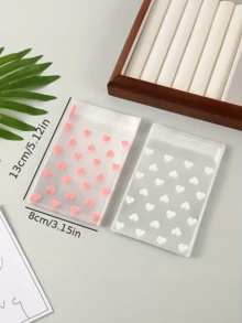 100个透明自粘心形包装袋，适用于饼干、糖果和甜点，适合礼品包装，是情人节、婚礼和其他新年节日送礼的理想选择。