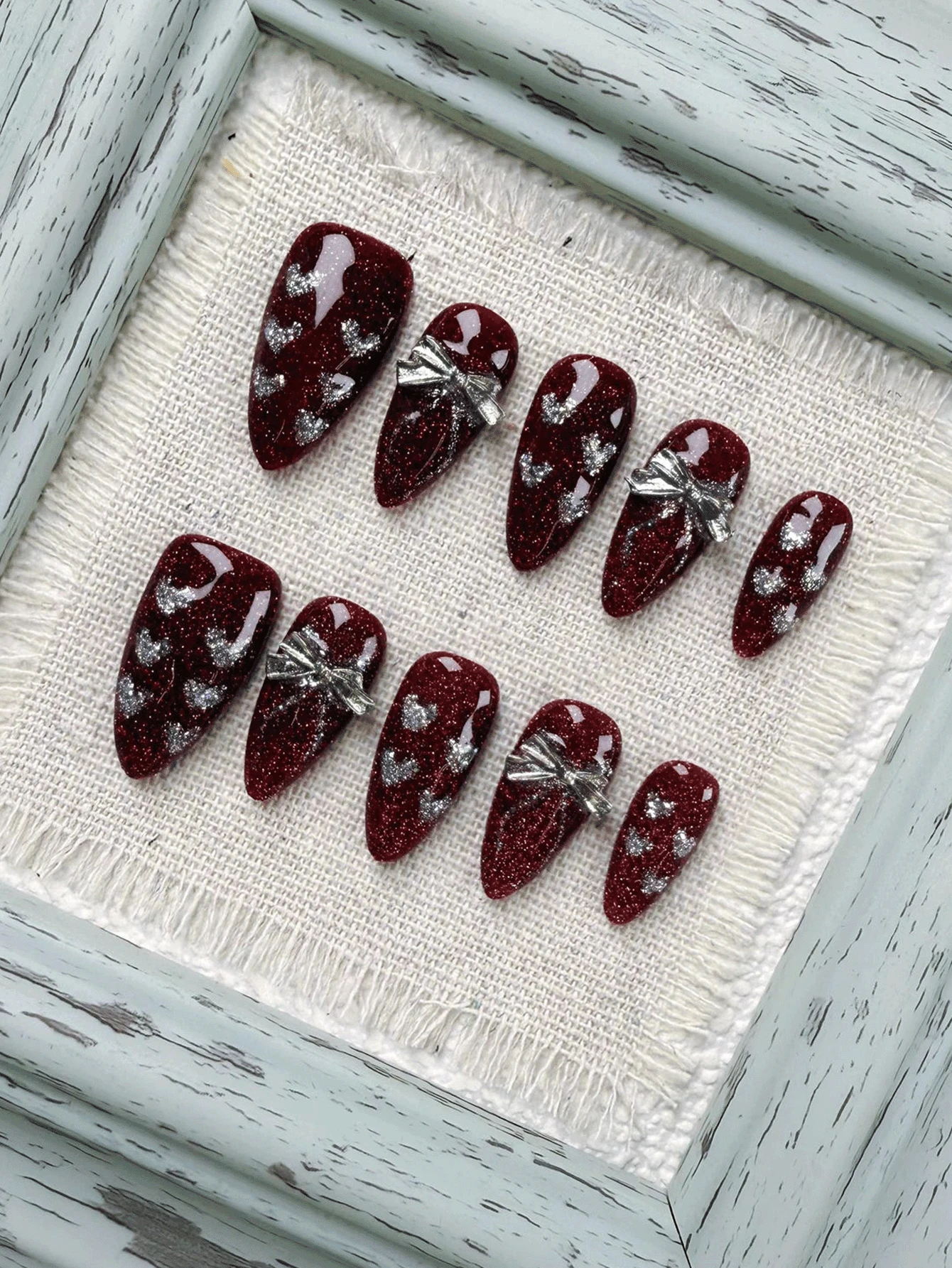 圣诞新年节日氛围，10片红色长杏仁形美甲贴片，饰以优雅的心形闪粉和金属蝴蝶结，尽显高端质感。纯手工制作，可佩戴，全粘可卸，适合上班族、学生、派对女孩以及各种场合的美甲爱好者。套装包含1支果冻胶和1把指甲锉。手工美甲贴片 - 紅色 - 查看 1