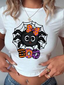 Playera estampada color blanca para mujer con diseño divertido y festivo de araña negra con moño naranja con lunares morados sobre telaraña acompañada de la palabra "BOO" en letras grandes y coloridas con estampados de rayas, murciélagos y puntos, ideal para un look juvenil, moderno y alegre en la temporada de Halloween y otoño - Blanco - Ver 1