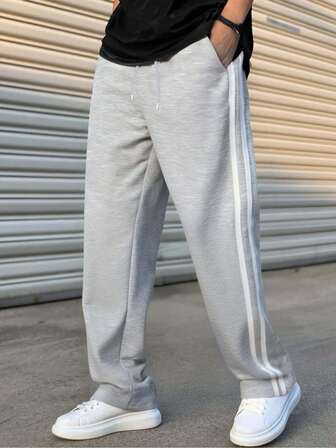 男士简约风格，适合日常休闲和运动。这款宽松裤子采用针织面料制成，材质为涤纶纤维。亲肤柔软，富有弹性，是送给男朋友、丈夫或家人的绝佳礼物。这款裤子体现了简约时尚的美学。男士抽绳腰部简约时尚裤。