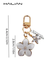 HAILIAN 这款轻巧优雅的樱花造型钥匙扣采用合金材质，专为女性设计，配有六瓣小花挂饰。作为旅行配件，它既可作包包挂饰，也可作车钥匙扣，更是情侣生日和节日的理想礼物。 - 白色 - 查看 6