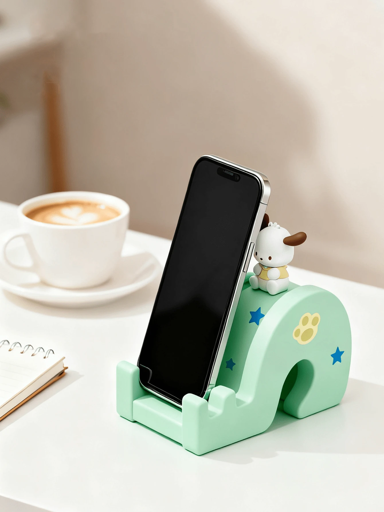 Giá đỡ điện thoại hình Pochacco chính hãng Sanrio – Pochacco màu trắng với tai nâu và quần áo màu vàng ngồi trên đế trượt màu xanh bạc hà, trang trí sao xanh và dấu chân vàng, đế silicon chống trượt, giá đỡ đa năng tương thích với iPhone/Android/Máy tính bảng, kích thước nhỏ gọn 10x4.5x7.4cm, đồ trang trí phòng dễ thương kiểu Kawaii và phụ kiện du lịch dành cho các bạn gái, thiếu niên và người sưu tầm Sanrio.