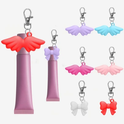 1 pieza Llavero con tapa de labios con alas de ángel/lazo, estuche portátil para almacenar brillo de labios, llavero para bálsamo labial, accesorio de viaje, tapa de llavero para lápiz labial, accesorio multifuncional, diseño de llavero portátil para lápiz labial, fácil de colgar en las llaves, accesorio para mujer