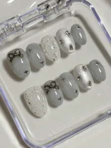 Bộ 10 miếng dán móng tay hình bầu dục màu xám và trắng với các chấm đen không đối xứng, hình ngôi sao, nơ và đá trang trí, mang đến vẻ ngoài nhẹ nhàng và tươi mới, bảo vệ móng tay cao cấp, bộ móng giả có thể tháo rời hoàn chỉnh phù hợp cho các quý cô công sở, sinh viên, các cô gái dự tiệc và mọi mùa, kèm theo 1 lọ sơn gel và 1 dũa móng. - Màu Xám nhạt - Xem 1