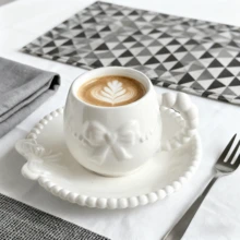 A Set Of Ceramic Coffee Cups And Saucers With Bow-Tie Relief Design (100-180ml Capacity). Perfect For Home Kitchens, Dining Rooms, Or Living Spaces. Each Cup Comes With A Matching Saucer. Ideal For Serving Tea, Coffee, Milk, Water, Or Juice. Suitable For Outdoor Use, Weddings, Parties, Gifting, Or Birthdays.
