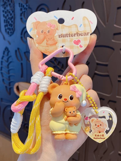 バターベア クロージングシリーズ ペンダント イエロー パジャマスタイル、ピンクのハート型フック、イエローの編み込みロープ、透明ハートアクリルタグがアクセント。柔らかいプラッシュ素材で作られ、鮮やかでかわいいパターン。鍵、バッグ、デスクの装飾に最適。鍵を楽しく飾ります。バターベアファン、コレクター、学生、ティーンに最適。友人/恋人への素敵な贈り物。