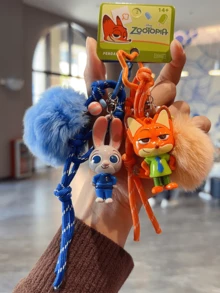 正版授权朱迪·霍普斯系列彩色胡萝卜吊坠，Q版朱迪造型，饰以浅蓝色大绒球、深蓝色编织绳和星形金属环，采用柔软乙烯基材质制成，非常适合挂在钥匙、包包上或作为桌面装饰，带来愉悦心情。是送给粉丝、爱人、学生、青少年、收藏家的理想礼物，也是送给爱人/朋友的贴心之选。