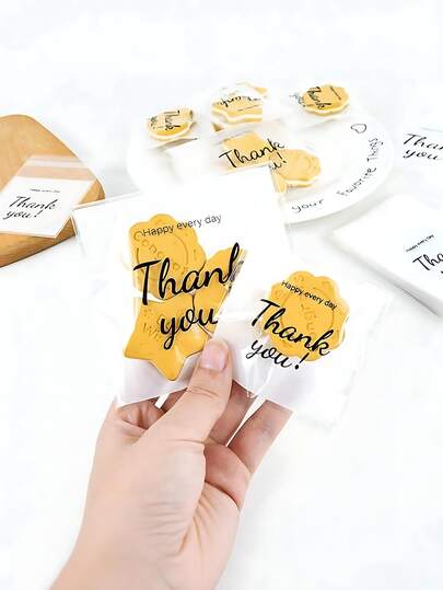 100个透明自封塑料礼品袋，印有“谢谢”字样，优雅手写风格，可重复密封，适用于派对、配饰包装以及赠送烘焙食品、饼干、巧克力等。