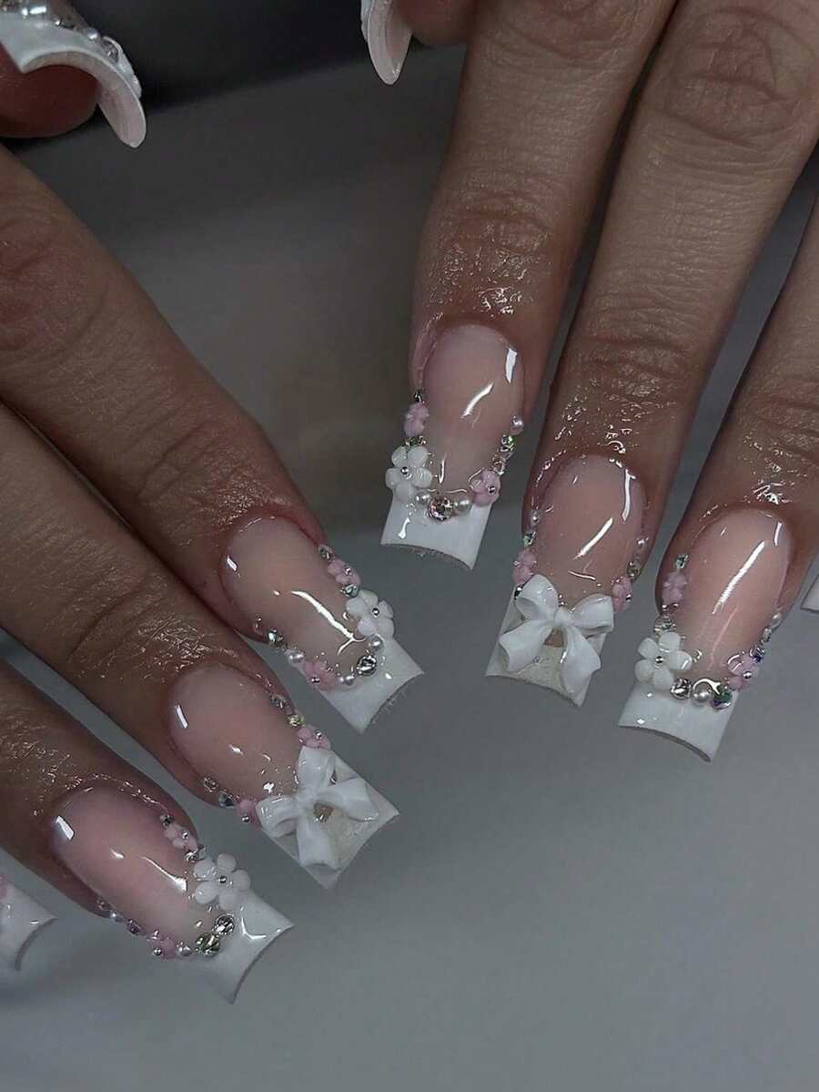24 pièces Faux ongles blancs français simples et élégants avec nœud 3D et strass floral. Rehaussez instantanément votre look. Conçu pour les femmes et les filles, comprend 1 pièce de bandes de gelée et 1 lime à ongles. Des bandes de gelée aléatoires sont expédiées. Fournitures pour les ongles - Blanc - Voir 1