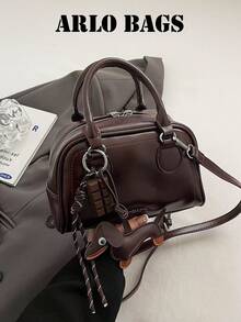 Ce sac de bowling de couleur unie à la mode est en matériau PU, avec une fermeture éclair et un design de lettre, décoré d'un pendentif de chien mignon. Son style minimaliste rétro et sa sensation de haute qualité le font se démarquer. Ce sac à main pour femme convient à un usage quotidien, est polyvalent et est un choix idéal pour les trajets, les courses, les sorties et le travail. C'est un sac pour femme de style vintage.