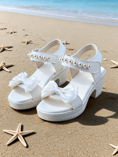 一双时尚仿皮凉鞋，饰有珍珠蝴蝶结，PU材质，防滑露趾设计，单带，粗跟，专为女孩设计。适合海滩拍照或夏季通勤。