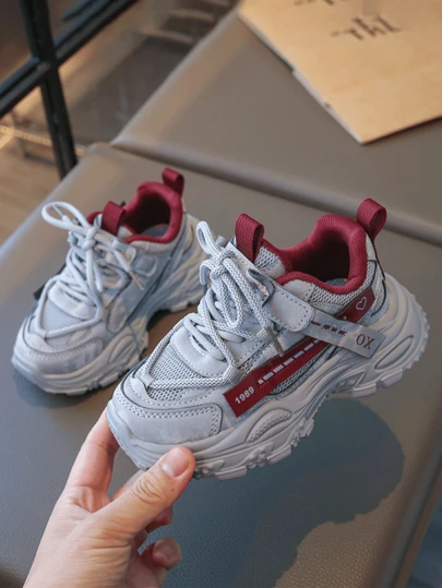 儿童灰色、白色和红色拼接运动鞋，透气网面，复古元素，舒适防滑休闲鞋