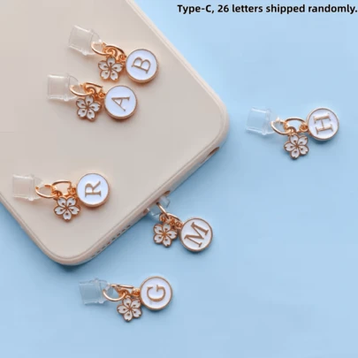 A White Phone Dust Plug Printed With The 26 Letters Of The Alphabet (A-Z) And A Flower Pendant. Suitable As A Birthday Or Holiday Gift. Compatible With Apple's Type-C Interface (26 Letters Shipped Randomly).