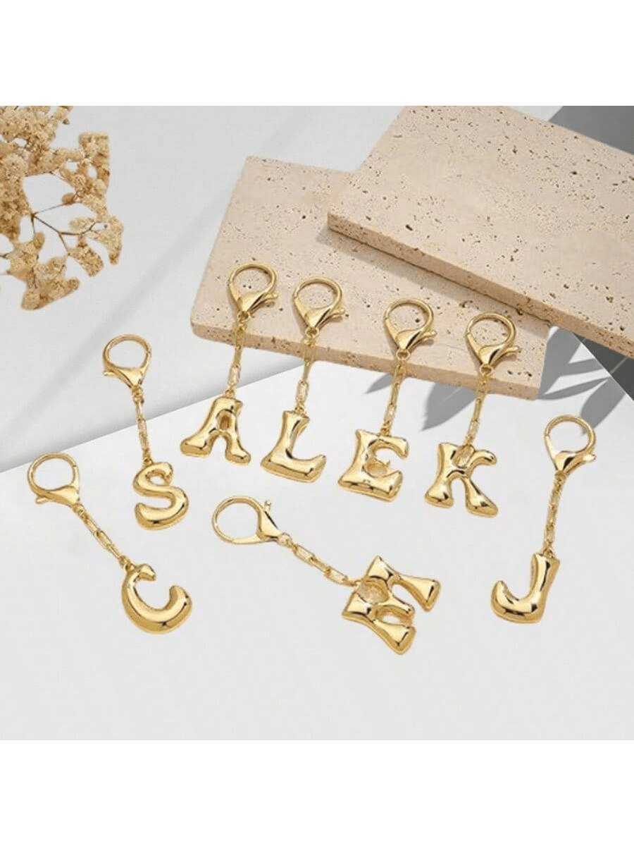 这款时尚的泡泡形钥匙扣吊坠，外形像气球，配有行李钩，并标有从 A 到 Z 的 26 个英文字母。