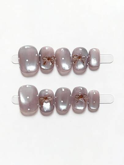10片纯手工制作的短椭圆形美甲贴片，灰紫色猫眼造型，带蝴蝶结，可爱Y2K风格，柔和亮片点缀，优雅迷人，适合女性和女孩，春夏秋冬皆宜，节日及日常美甲用品。