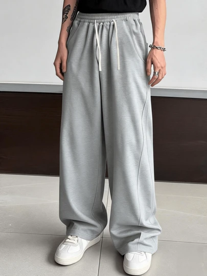 男士宽松休闲灰色长裤，抽绳松紧腰带，舒适透气，休闲复古风格，适合日常穿着和通勤。