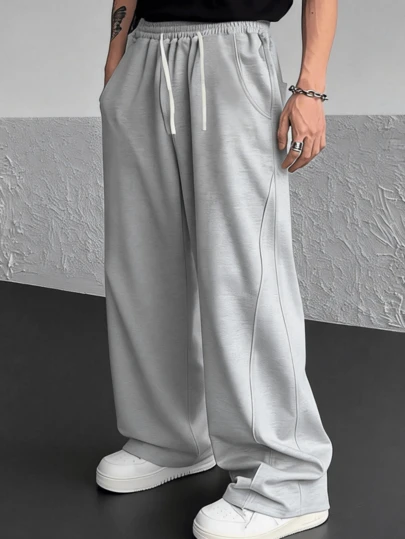 男士宽松休闲灰色长裤，抽绳松紧腰带，舒适透气，休闲复古风格，适合日常穿着和通勤。