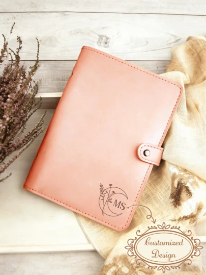 Personalizowany segregator skórzany formatu A6 (z możliwością grawerowania inicjałów) – wysokiej jakości okładka ze sztucznej skóry w pastelowych kolorach, z liniowanymi stronami wewnętrznymi w zestawie; dostępna jest również wersja z pojedynczą okładką.