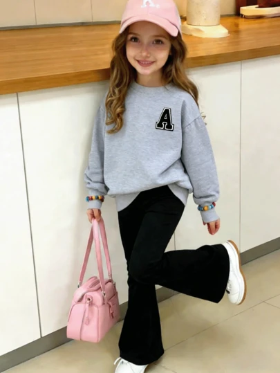 少女套装，黑色圆领卫衣搭配黑色喇叭裤，饰有字母印花图案。柔软舒适，可机洗，休闲时尚，适合旅行、聚会和上学穿着。也适合上学、度假和购物穿着。