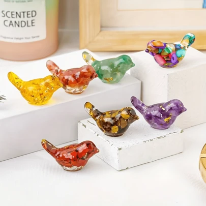 这款水晶碎片鸟摆件完美融合了自然之美、绚丽色彩和精神象征意义，旨在为您的家注入神奇的魔力和正能量。它采用优质树脂精制而成，镶嵌天然水晶碎片并饰以金箔，兼具艺术美感、百搭用途和持久品质。无论是摆放在书桌、书架还是祭坛，它都是理想之选，也是馈赠亲友的贴心礼物。