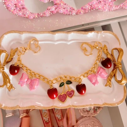 Hermosos adornos hechos a mano para bolsos tipo monedero con diseños de cerezas y moños, que embellecerían cualquier bolso de una manera muy