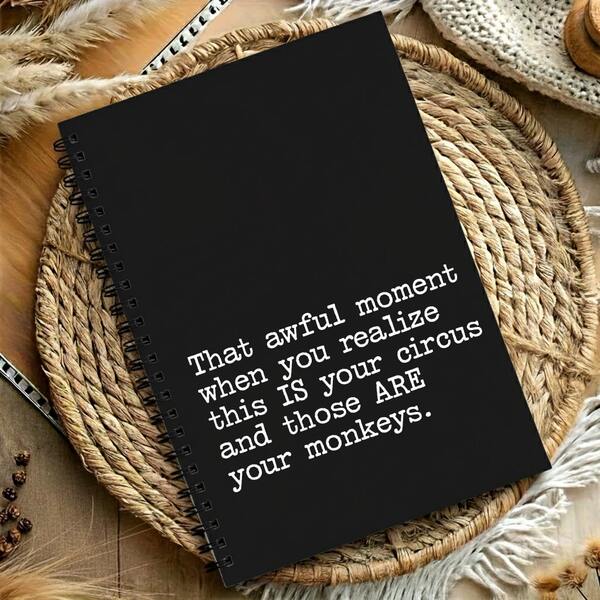 1本带讽刺语录的螺旋笔记本，黑色封面，趣味文案备忘录，创意办公减压文具，适用于职场。