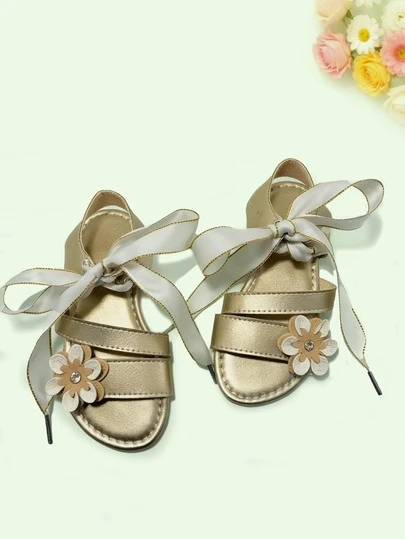 Giày sandal đế bằng màu vàng ánh kim thời trang mùa hè mới cho bé gái, họa tiết hoa, thiết kế buộc dây, sành điệu và thoải mái, đa năng cho kỳ nghỉ, tiệc tùng và mặc hàng ngày.
