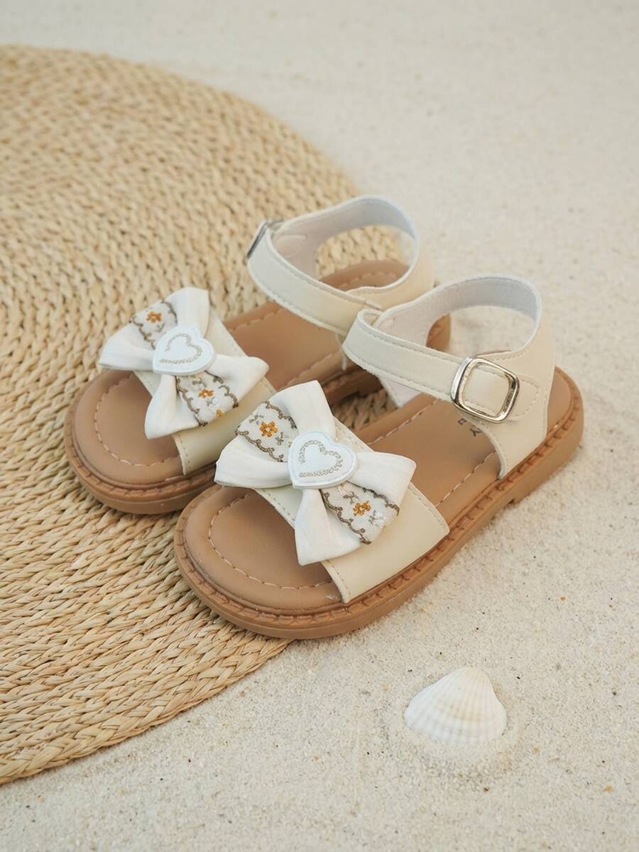 3-12 Jahre alte Mädchen Schleifen Sandalen, beige matte PU Weichmaterial, 3D Schleife & Herz Stickerei, verstellbarer Metallschnalle, Retro Flach Sommerschuhe - Aprikosenfarben - Übersicht 1