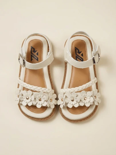 Giày sandal đế bệt điều chỉnh được cho bé gái, giày mùa hè hở mũi bằng da PU màu trắng ngà với nơ thêu 3D hình hoa ruy băng, cánh hoa và họa tiết lá chuyển màu, dành cho bé từ 3-12 tuổi.