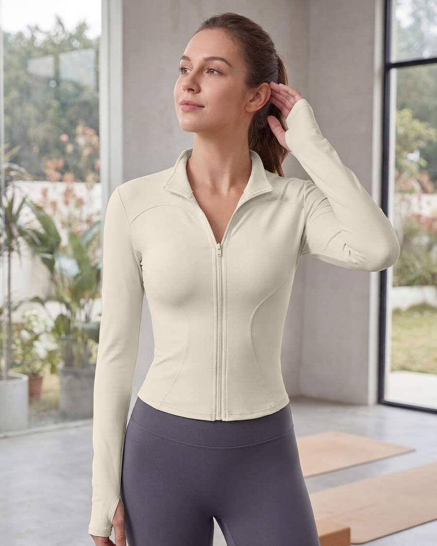 Chaqueta deportiva de manga larga con cremallera de color liso para mujer, corte ajustado y puños con abertura para el pulgar, ideal para fitness, yoga y running. - Marfil - Ver 1