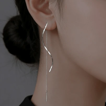一对简约时尚的S形扭曲设计耳环，配以精致的链条和串珠点缀，适合日常通勤和社交场合佩戴。