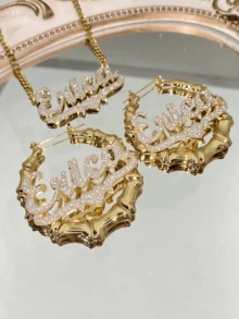 Bộ trang sức hai lớp mờ khắc tên gồm bông tai và dây chuyền hình vòng tre 50mm tùy chỉnh và dây chuyền thép không gỉ mạ vàng với lớp hoàn thiện phun cát màu hồng. Bộ trang sức thép không gỉ cá nhân hóa này là món quà trang sức khắc tên mạ vàng hoàn hảo cho Ngày của Mẹ hoặc Ngày Valentine, được đóng gói đẹp mắt trong hộp quà có nơ. - Mờ - Kiểu 3 - Xem 2