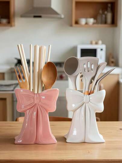 Organisateur de couverts en résine avec nœud papillon mignon, un outil de rangement multifonctionnel de cuisine pouvant contenir des baguettes, des cuillères, des fouets et plus encore. Boîte de rangement décorative et élégante, disponible en rose et blanc, parfaite pour garder votre plan de travail de cuisine propre et beau. Un organisateur de couverts élégant qui allie fonctionnalité et esthétique, un incontournable pour les passionnés de cuisine et les amateurs de décoration intérieure.