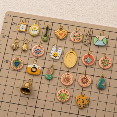 1件复古珐琅滴水吊坠饰品，18k不锈钢材质，图案元素包括心形、花朵、相机、塑料袋、仙人掌、金色水滴、相框、铃铛、吉他、黑八号球等。防水防褪色，适合女性或情侣佩戴，可作手链吊坠、珠宝吊坠、项链吊坠、夏季珠宝设计、手机链吊坠、钥匙扣吊坠等。