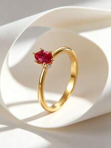 Charm-In Nhẫn solitaire ruby tối giản, mạ vàng đồng với đá CZ đỏ hình bầu dục và điểm nhấn pha lê nhỏ, thiết kế đơn giản phù hợp cho đeo hàng ngày và thường ngày. - Vàng - Xem 1