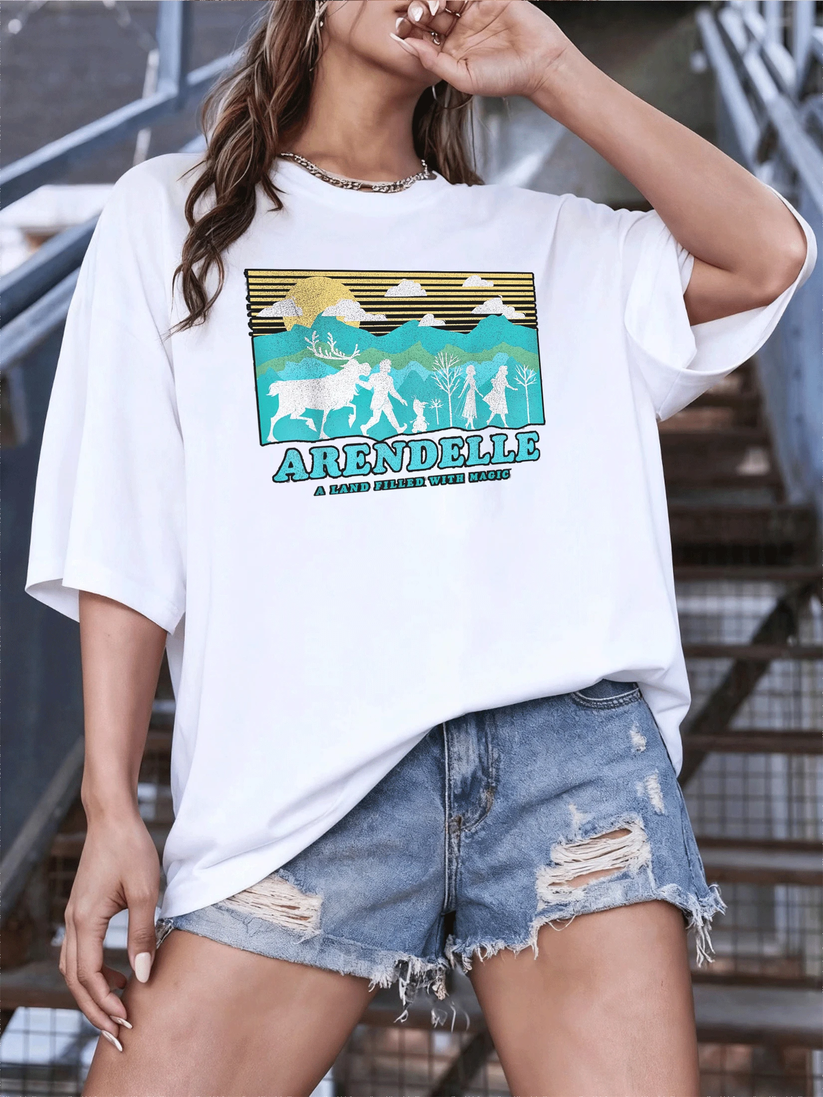 Paisaje mágico con figuras caminando bajo montañas doradas y cielo azul que evoca aventura y fantasía camiseta de mujer con estampado artístico y toque luminoso ideal para uso diario - Blanco - Ver 1