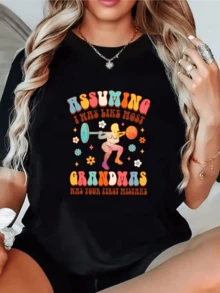 Colorful Illustration Depicts A Strong Grandmother Lifting Weights Surrounded By Small Flowers, Symbolizing Energy, Joy, And Feminine Confidence. Comfortable, Modern, Casual Women's T-Shirt For Everyday Wear. - 黑色 - 查看 1