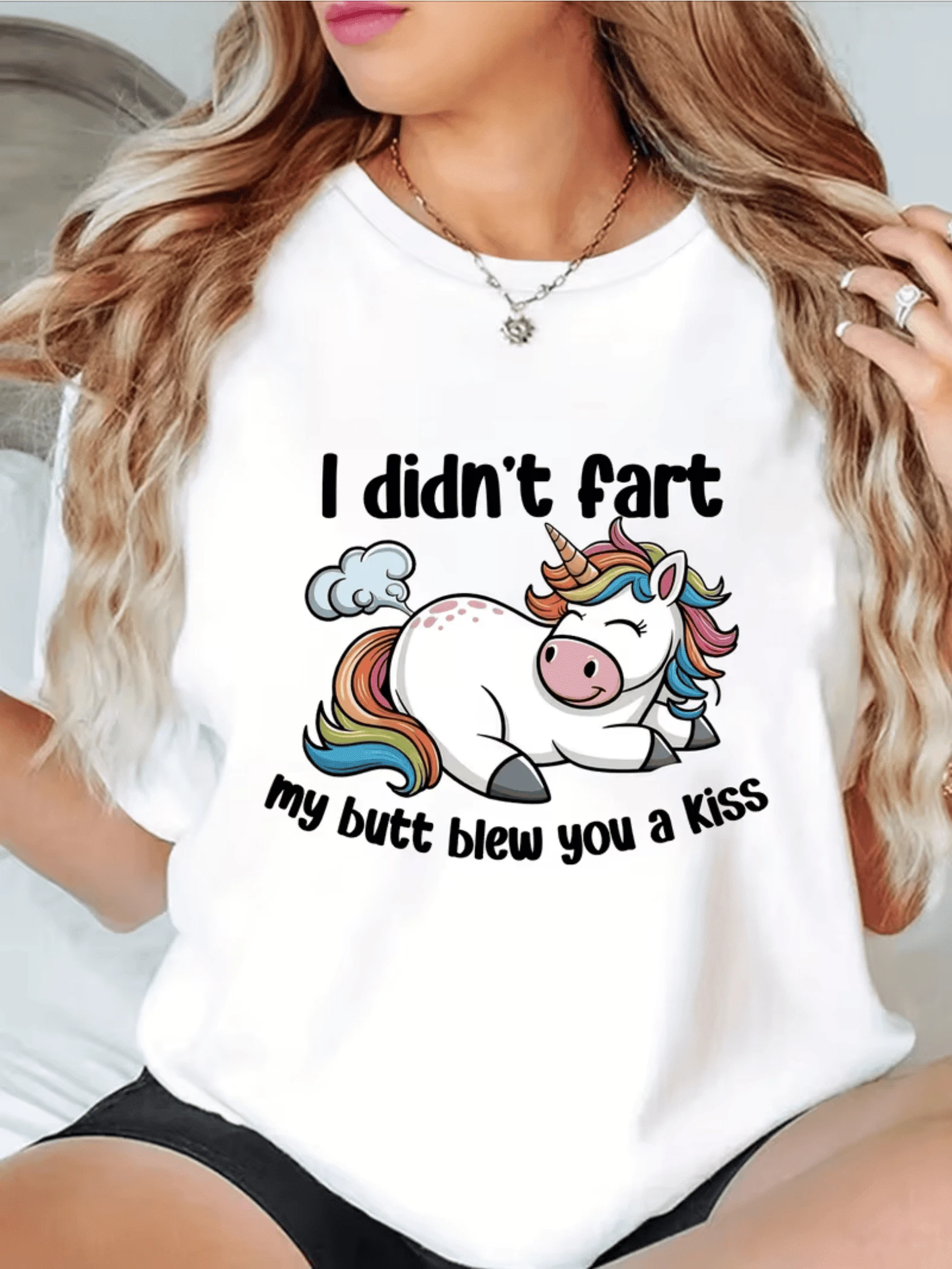 Un unicornio colorido sonriente que lanza un pequeño soplo de aire en forma de beso simbolizando humor inocente y alegría divertida camiseta de mujer casual divertida 2024 - Blanco - Ver 1