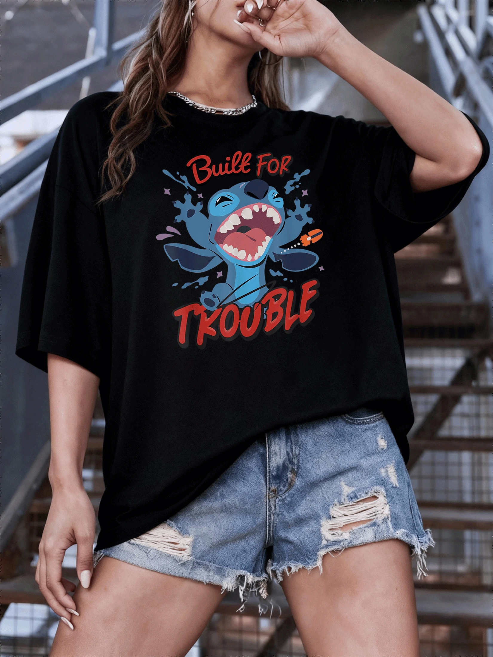 Figura de criatura azul traviesa gritando con energía salpicaduras de color y letras rojas vivas que transmiten humor y vitalidad camiseta de mujer casual moderna divertida - Negro - Ver 1