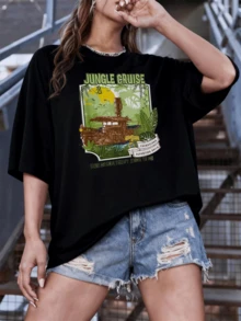 Selva aventurera con barco antiguo navegando entre hojas tropicales bajo un cielo amarillo con aves y un jaguar que representa la energía y la exploración camiseta de mujer casual moderna - Negro - Ver 1