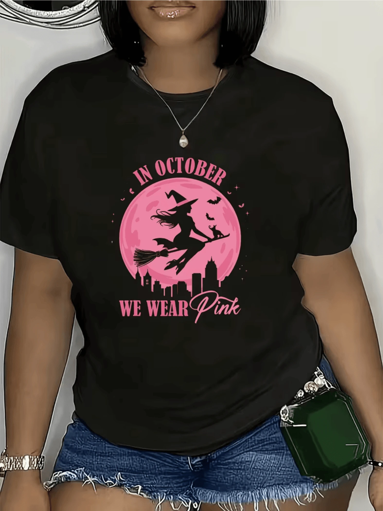 Witch Flying On A Broomstick In Front Of A Large Pink Moon Symbolizing Feminine Strength And Unity In October With A Small Cat Accompanying Her Over A City Alluding To The Magical Night. Modern Casual Women's T-Shirt - 黑色 - 查看 1
