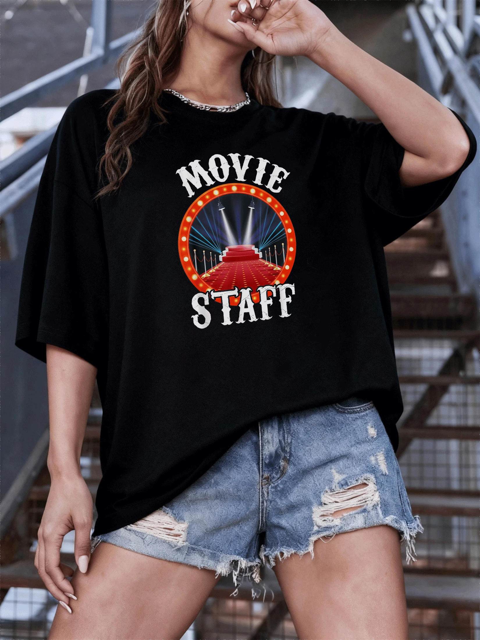 Escenario iluminado con alfombra roja rodeado de luces doradas que evocan glamour cinematográfico y espíritu creativo ideal para amantes del cine y el arte camiseta de mujer casual moderna cómoda para uso diario - Negro - Ver 1