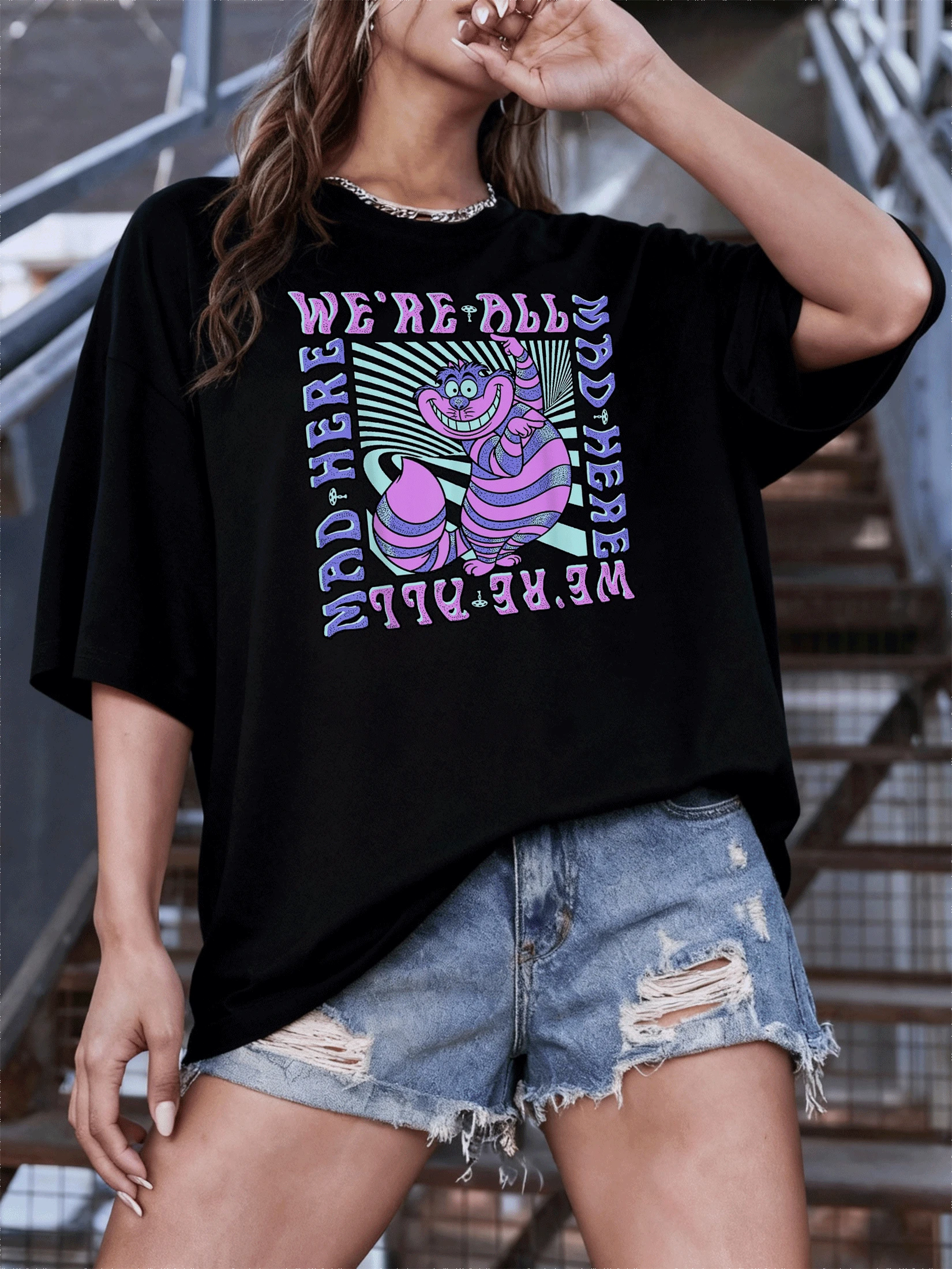 Gato sonriente de rayas moradas y rosas rodeado de espirales hipnóticas que simbolizan la locura divertida y la fantasía surrealista camiseta de mujer moderna y cómoda para uso casual - Negro - Ver 1