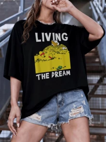 Figura de pato relajado sobre una gran montaña de monedas doradas representando abundancia felicidad y disfrute pleno de los sueños alcanzados camiseta de mujer con mensaje divertido y moderno ideal para uso diario - Negro - Ver 1