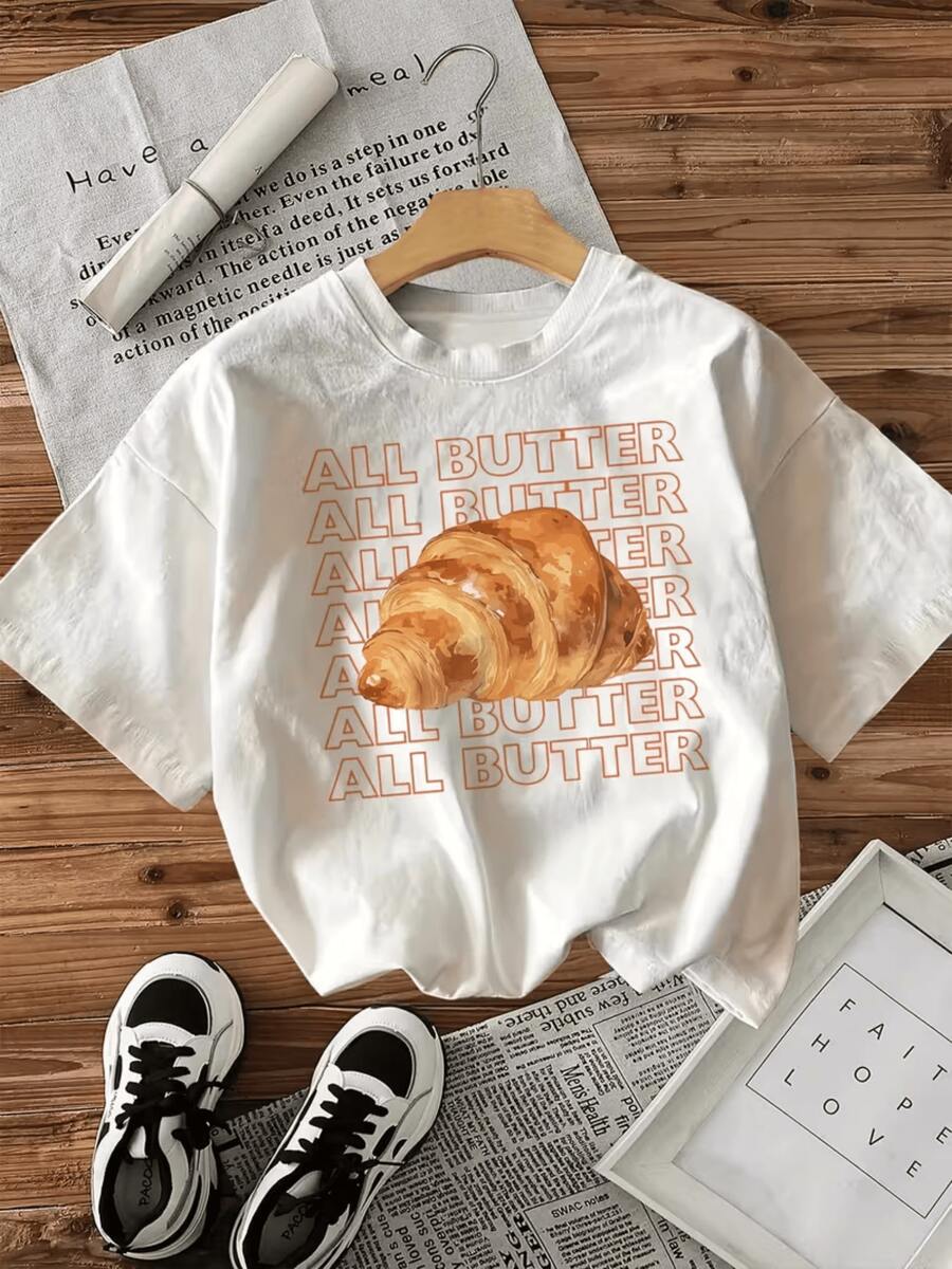 Croissant dorado que simboliza la calidez de una mañana tranquila y el placer de disfrutar un desayuno delicioso con aroma mantecoso camiseta de mujer casual cómoda para uso diario - Blanco - Ver 1