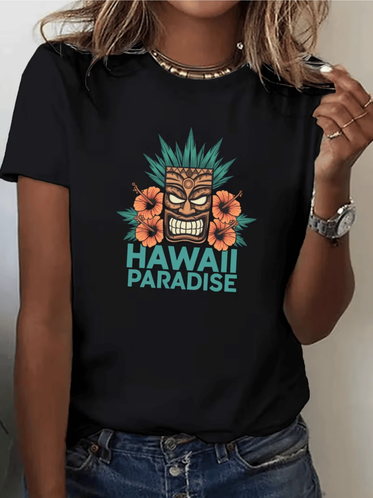 Máscara rodeada de flores tropicales y hojas verdes que transmite energía positiva espíritu aventurero y sensación de paraíso exótico ideal para días soleados camiseta de mujer casual cómoda y moderna - Negro - Ver 1