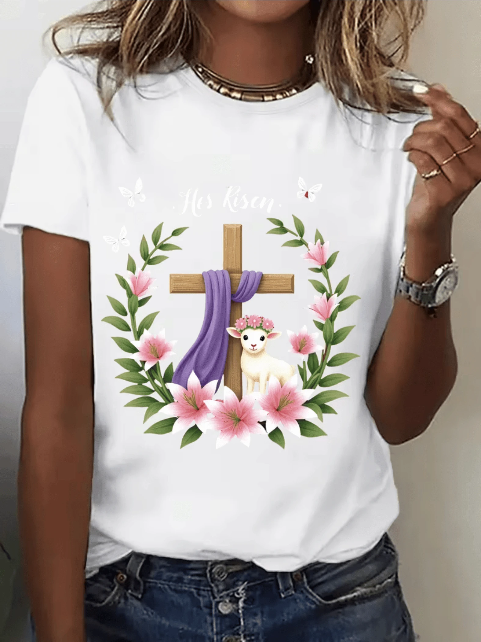 Cruz de madera rodeada de flores rosadas y hojas verdes con manto púrpura símbolo de esperanza y renacimiento junto a un tierno cordero con corona floral camiseta de mujer casual cómoda y elegante - Blanco - Ver 1
