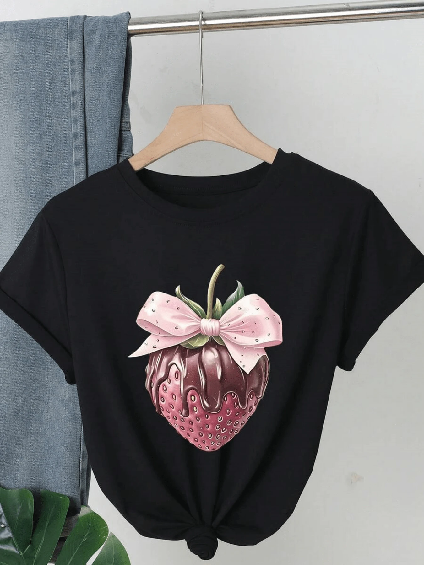Fresa cubierta de chocolate con lazo rosado simboliza dulzura encanto y diversión evocando alegría y frescura perfecta para mujeres que aman lo tierno y lo moderno camiseta de mujer casual cómoda atractiva para uso diario - Negro - Ver 1